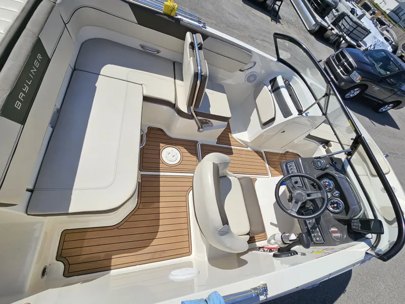 Slide: The Image of 2019 Bayliner VF5 boat interior with seating, steering wheel, and wood-style flooring. - 11