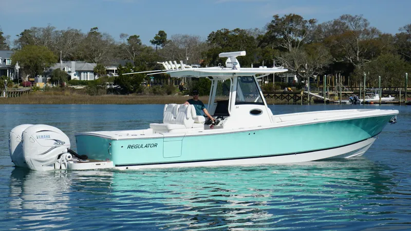 Slide: The Image of 2023 Regulator 34 boat on calm water, featuring sleek design and twin Yamaha engines. - 11