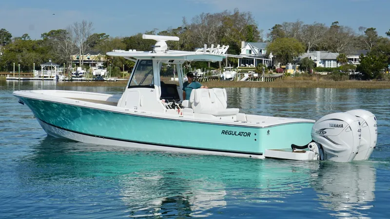 Slide: The Image of 2023 Regulator 34 boat on calm water, featuring a sleek design and Yamaha outboard engine. - 13