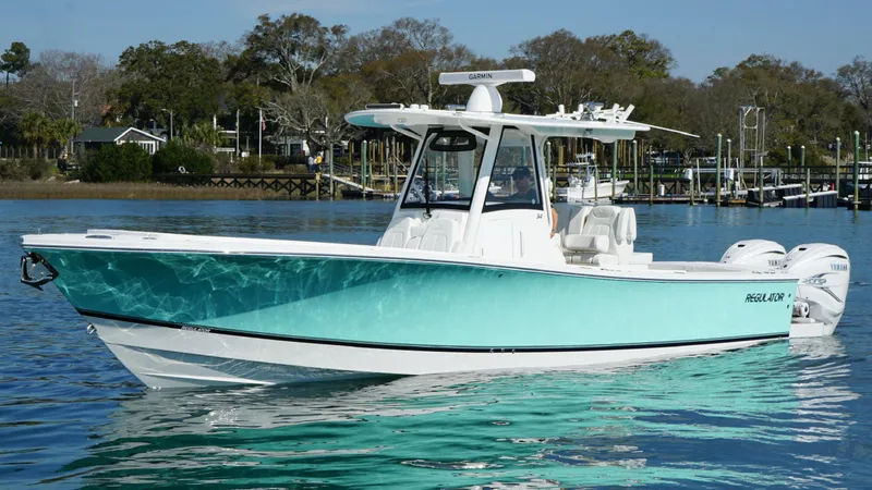 Slide: The Image of 2023 Regulator 34 boat on calm water, featuring a sleek turquoise and white design. - 2