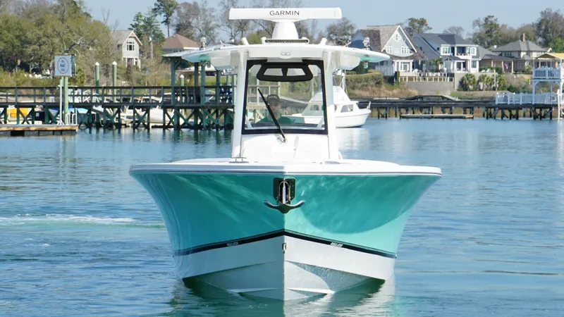 Slide: The Image of 2023 Regulator 34 boat on calm water near a dock with houses in the background. - 6