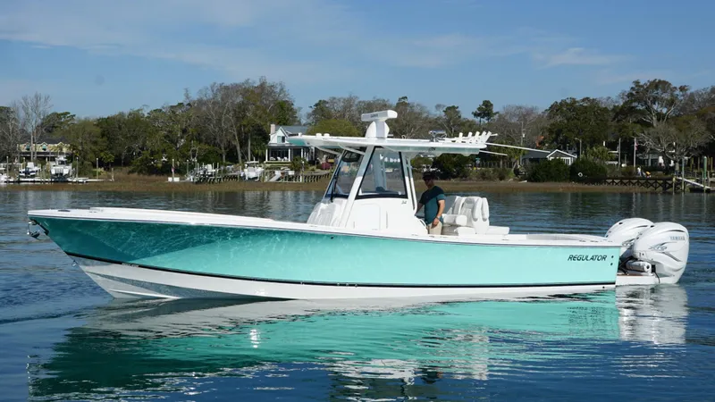 Slide: The Image of 2023 Regulator 34 boat on calm water, featuring sleek design and twin engines. - 9