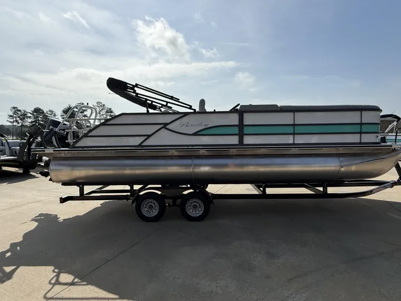 Slide: The Image of 2025 Bentley Pontoons Legacy Swingback 240 on trailer, side view, outdoors. - 12