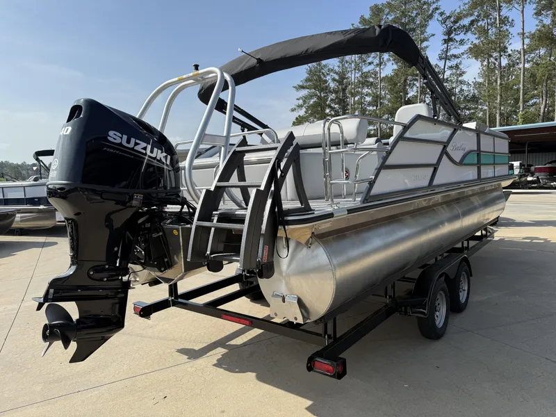Slide: The Image of 2025 Bentley Pontoons Legacy Swingback 240 with Suzuki engine on trailer, outdoor setting. - 3