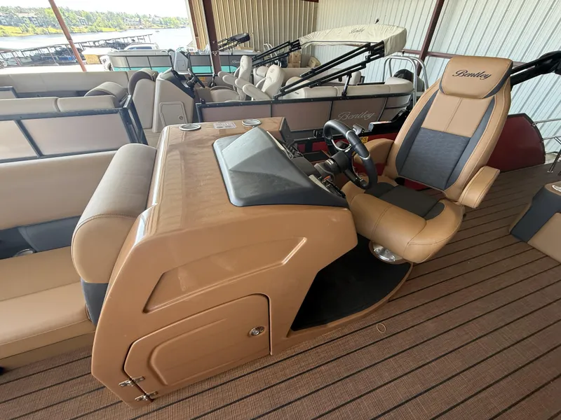 Slide: The Image of 2025 Bentley Pontoons Elite 253 Swingback Dual Captain interior with tan seating and steering console. - 11