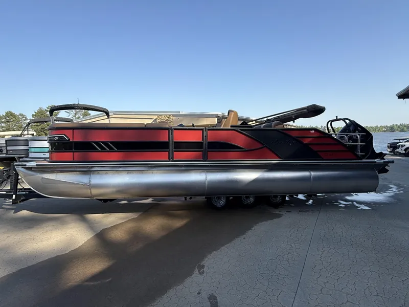 Slide: The Image of 2025 Bentley Pontoons Elite 253 Swingback Dual Captain Full Tube, red and black design, docked. - 3