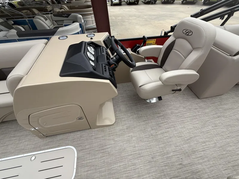 Slide: The Image of 2025 Bentley Pontoons Legacy Navigator 243 helm with beige captain's chair and dashboard. - 11