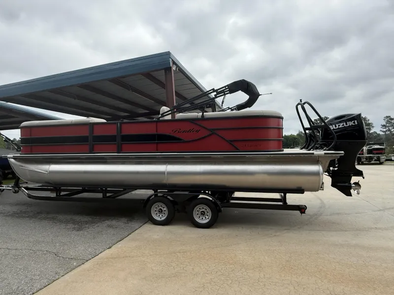 Slide: The Image of 2025 Bentley Pontoons Legacy Navigator 243 on trailer, featuring Suzuki outboard motor. - 8