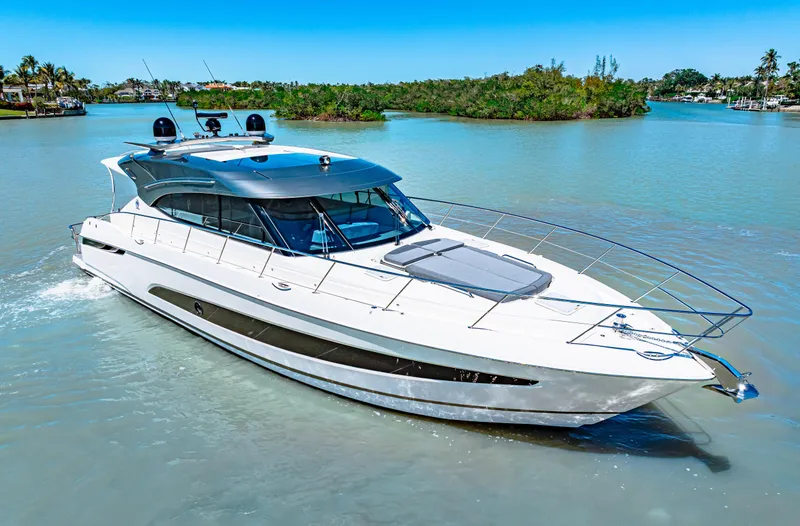 Slide: The Image of 2022 Riviera 5400 Sport Yacht cruising on a sunny day in a serene waterway. - 1