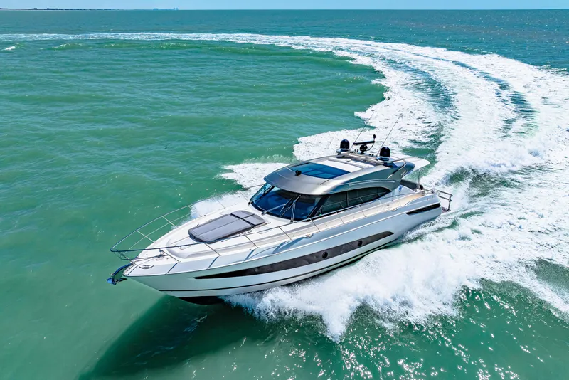 Slide: The Image of 2022 Riviera 5400 Sport Yacht cruising on open water, creating a dynamic wake. - 17