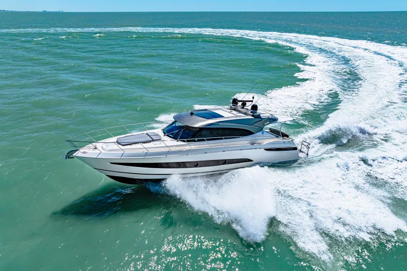 Slide: The Image of Riviera 5400 Sport Yacht 2022 cruising on open water, creating a dynamic wake. - 18