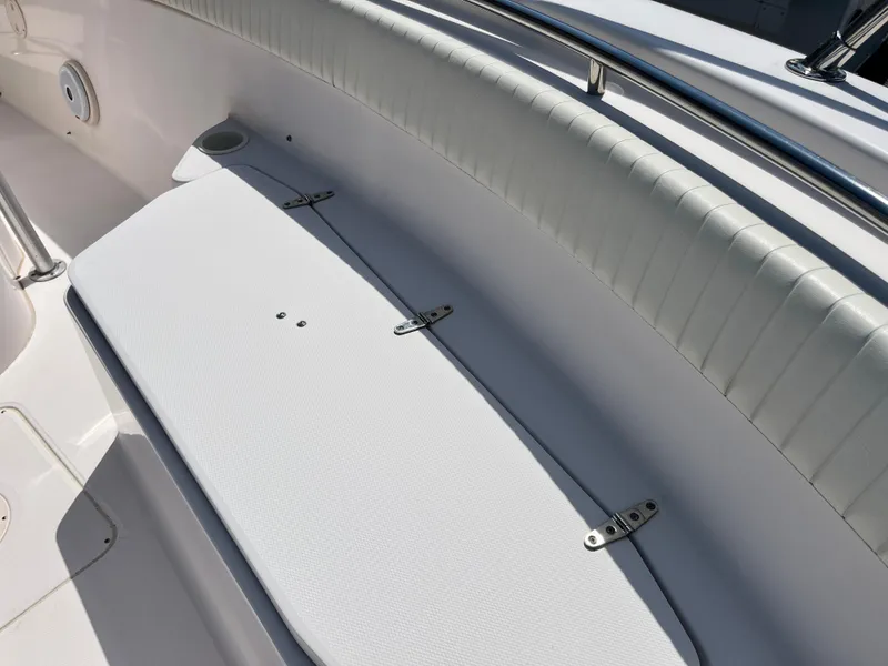 Slide: The Image of 2003 Grady-White Chase 273 boat interior with white cushioned seating and storage compartment. - 12