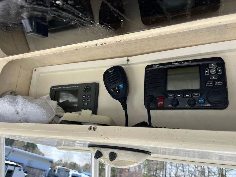 Slide: The Image of 2003 Grady-White Chase 273 boat dashboard with radio and navigation equipment. - 21