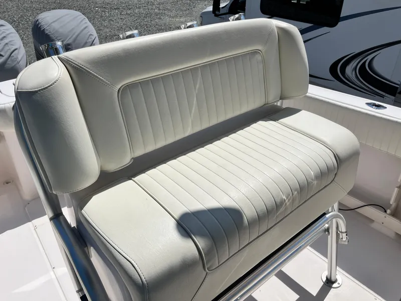 Slide: The Image of 2003 Grady-White Chase 273 boat seat with white upholstery and metal frame. - 24
