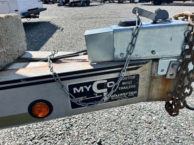 Slide: The Image of Trailer hitch with chains and label, parked on gravel. Grady-White Chase 273, 2003 model. - 5