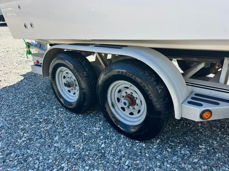 Slide: The Image of Trailer wheels of a 2003 Grady-White Chase 273 boat on gravel surface. - 6