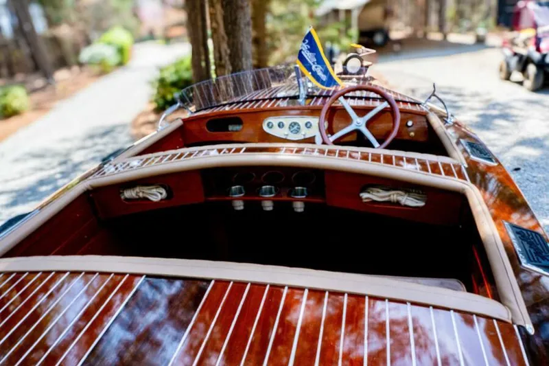 Slide: The Image of 1941 Hacker-Craft Deluxe boat with polished wood finish and classic steering wheel. - 13