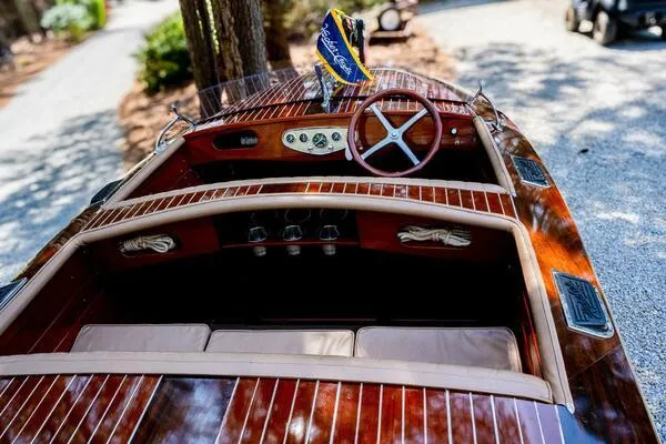 Slide: The Image of 1941 Hacker-Craft Deluxe boat with polished wood finish and classic steering wheel. - 15