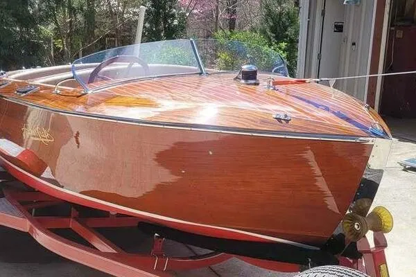 Slide: The Image of 1941 Hacker-Craft Deluxe wooden boat on trailer, showcasing classic design and polished finish. - 2