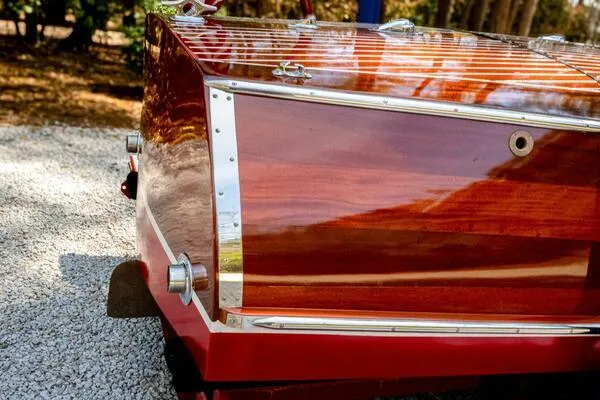 Slide: The Image of 1941 Hacker-Craft Deluxe boat with polished wooden finish, displayed outdoors. - 24