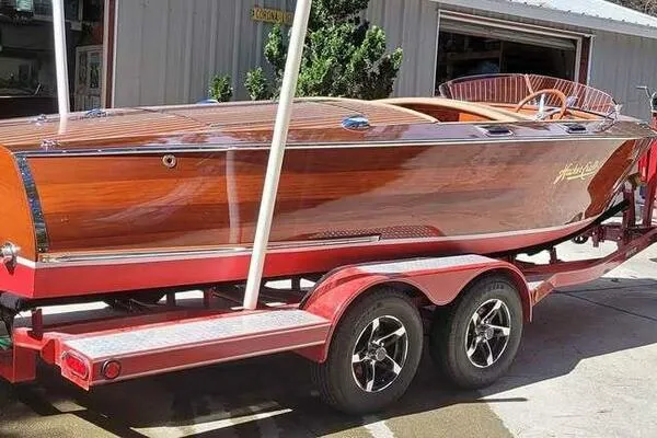 Slide: The Image of 1941 Hacker-Craft Deluxe wooden boat on a red trailer, showcasing classic design and craftsmanship. - 3