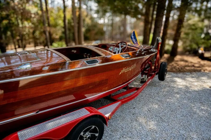 Slide: The Image of 1941 Hacker-Craft Deluxe boat on trailer in wooded area. - 38