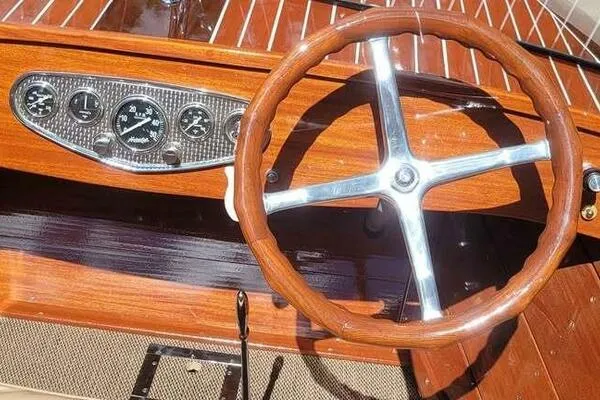 Slide: The Image of 1941 Hacker-Craft Deluxe boat dashboard with wooden steering wheel and vintage gauges. - 45