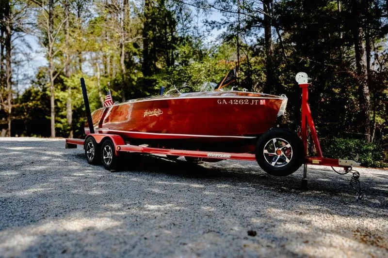 Slide: The Image of 1941 Hacker-Craft Deluxe boat on trailer, surrounded by trees. - 6