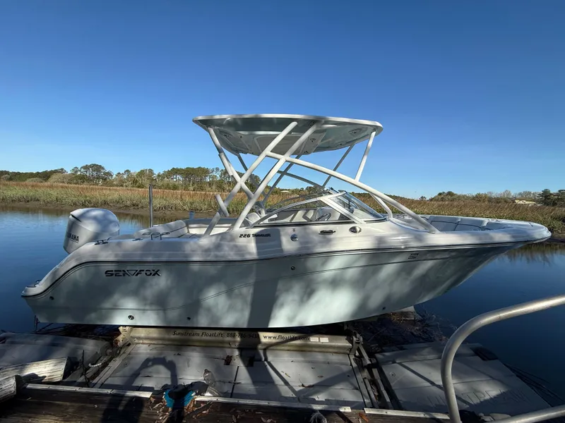 Slide: The Image of 2020 Sea Fox 226 Traveler boat docked on calm water under clear blue sky. - 1