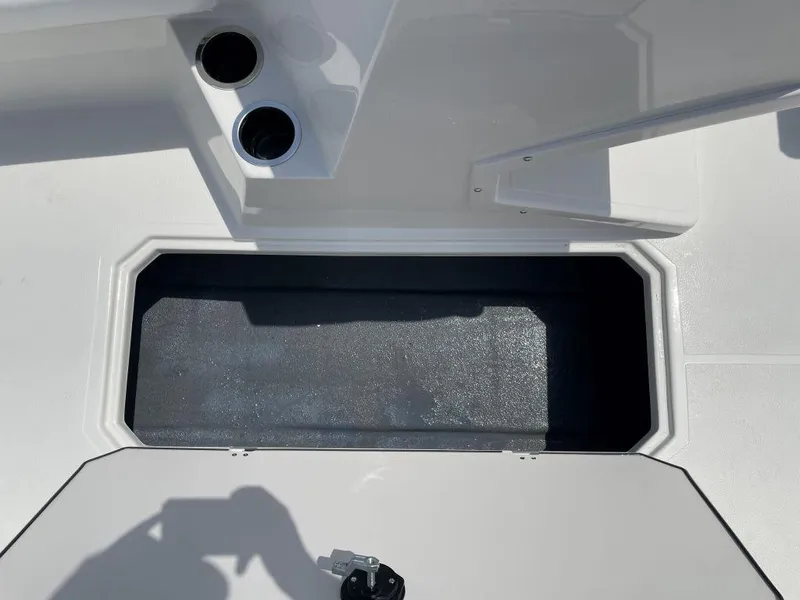 Slide: The Image of 2025 Starcraft SVX 171 OB boat storage compartment with cup holders, open hatch, and shadow. - 19
