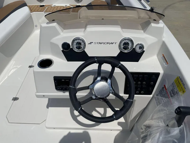 Slide: The Image of 2025 Starcraft SVX 171 OB boat dashboard with steering wheel and control panel. - 6