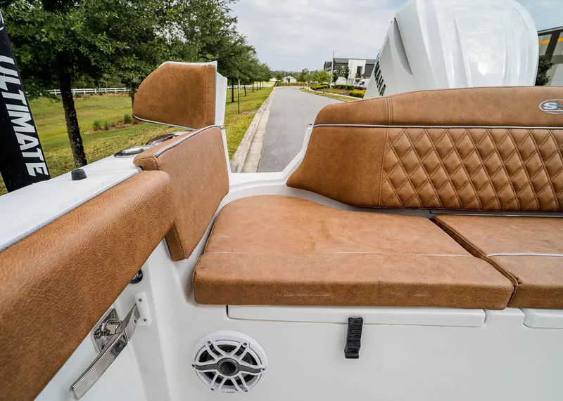 Slide: The Image of 2025 Sea Hunt Ultra 255 SE boat with tan leather seating and speaker detail. - 13