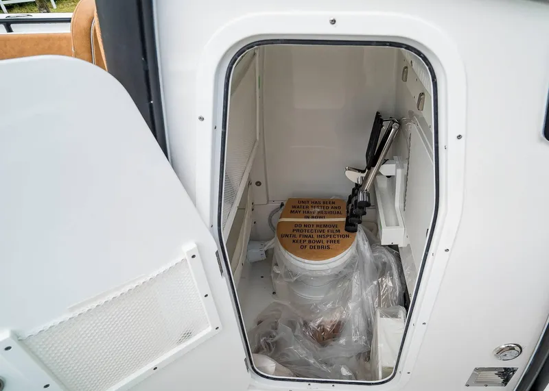 Slide: The Image of 2025 Sea Hunt Ultra 255 SE boat interior with enclosed marine toilet. - 16