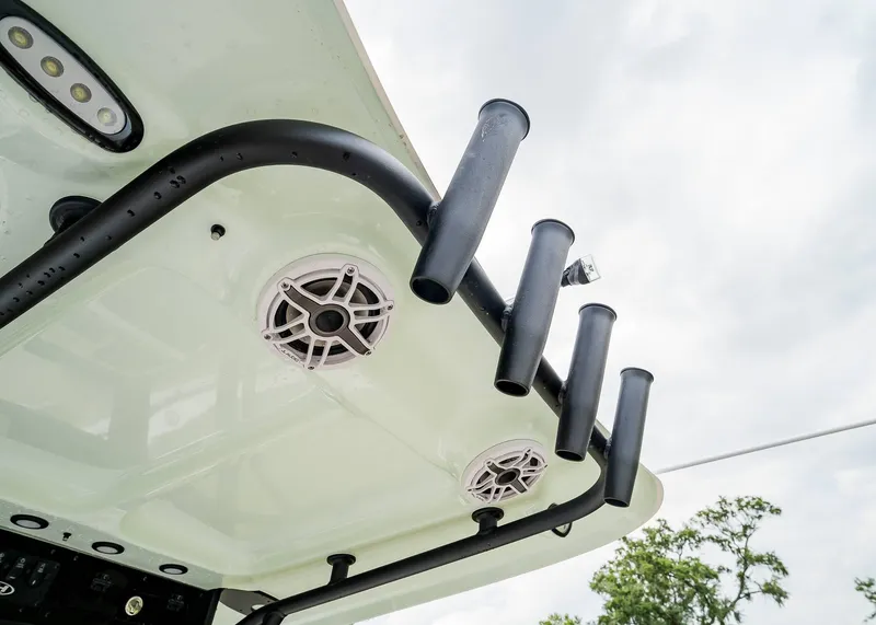 Slide: The Image of 2025 Sea Hunt Ultra 255 SE boat with rod holders and speakers under a cloudy sky. - 22