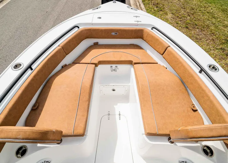 Slide: The Image of 2025 Sea Hunt Ultra 255 SE boat with tan cushioned seating and white deck. - 26