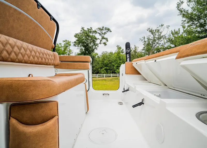Slide: The Image of 2025 Sea Hunt Ultra 255 SE boat interior with tan seating and storage compartments. - 8