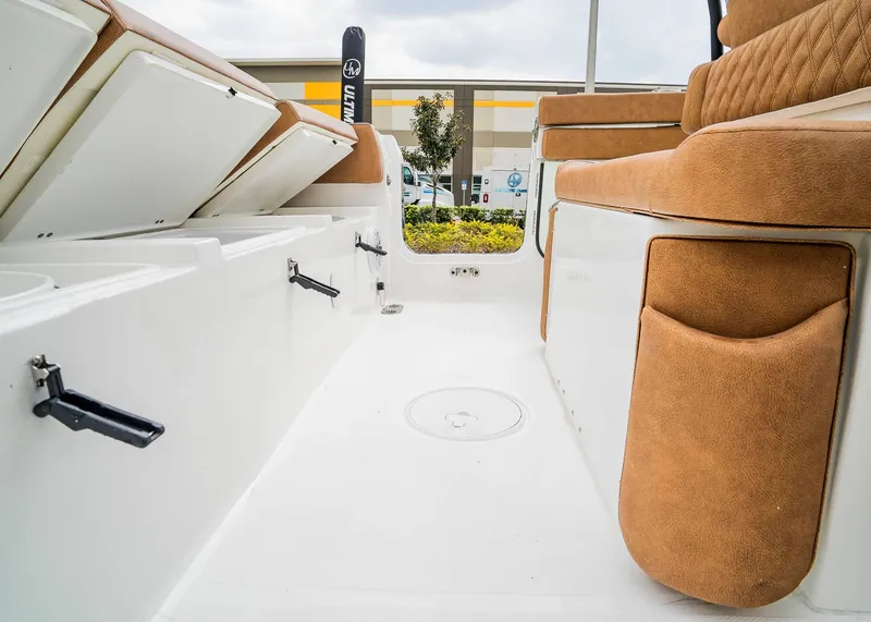 Slide: The Image of 2025 Sea Hunt Ultra 255 SE boat interior with tan seating and storage compartments. - 9