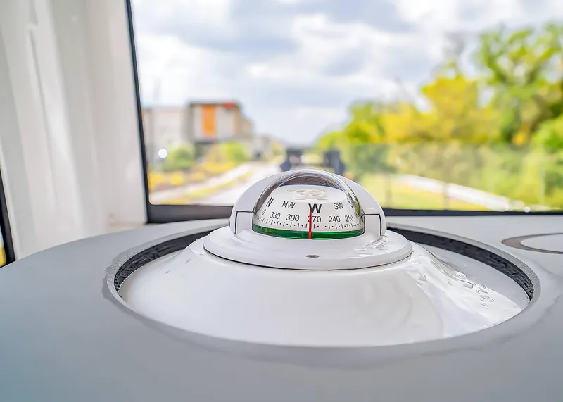 Slide: The Image of Compass on Sea Hunt Ultra 275 SE boat, 2025 model, with blurred outdoor background. - 24