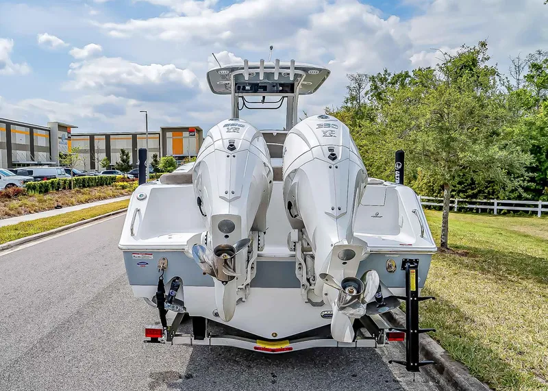Slide: The Image of 2025 Sea Hunt Ultra 275 SE boat with dual engines, parked on a street. - 5