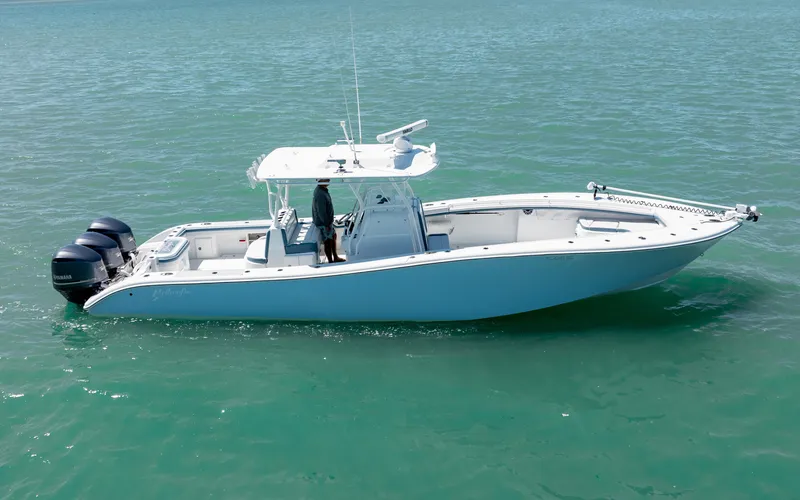 Slide: The Image of 2019 Yellowfin 36 boat on calm turquoise water, featuring dual outboard motors. - 11