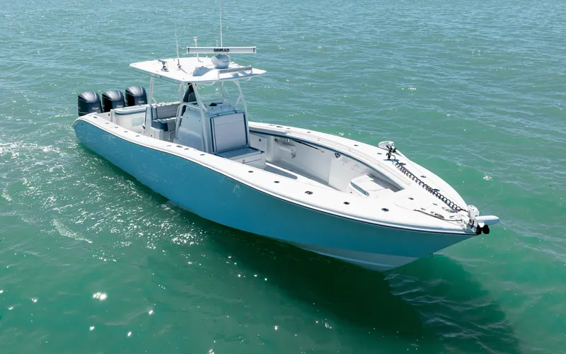 Slide: The Image of 2019 Yellowfin 36 boat on open water, featuring triple outboard engines. - 15