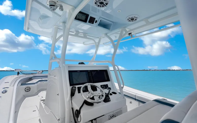 Slide: The Image of 2019 Yellowfin 36 boat interior with steering wheel, ocean view, and clear blue sky. - 19