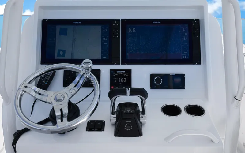 Slide: The Image of Control panel of a 2019 Yellowfin 36 boat with steering wheel and navigation screens. - 20