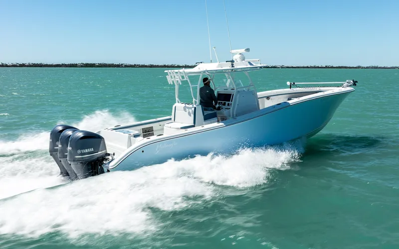Slide: The Image of 2019 Yellowfin 36 boat cruising on turquoise water with triple Yamaha engines. - 4