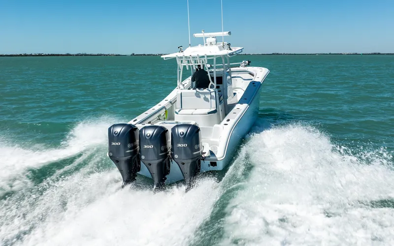 Slide: The Image of 2019 Yellowfin 36 boat cruising on open water with triple outboard engines. - 6