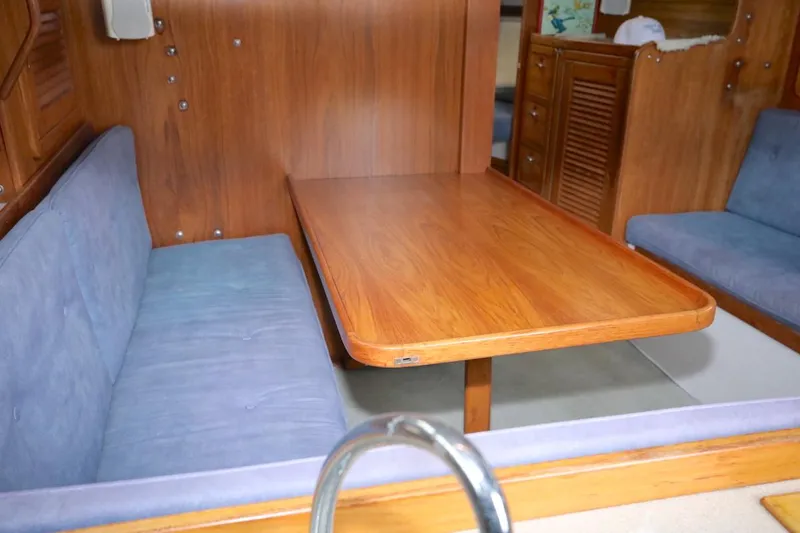 Slide: The Image of Interior of a 1995 Catalina 30 yacht with wooden table and blue cushions. - 24