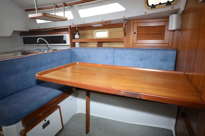 Slide: The Image of Interior of a 1995 Catalina 30 yacht with wooden table and blue cushions. - 25