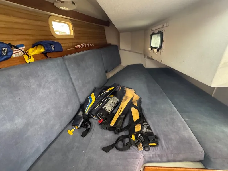 Slide: The Image of Interior of a 1995 Catalina 30 yacht with blue cushions and life jackets. - 30