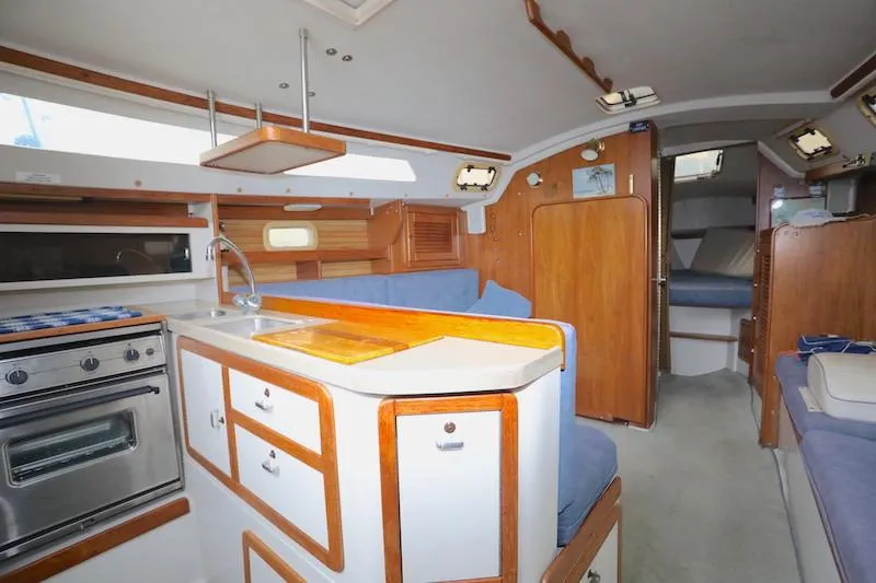 Slide: The Image of Interior of a 1995 Catalina 30 sailboat with kitchen and seating area. - 32