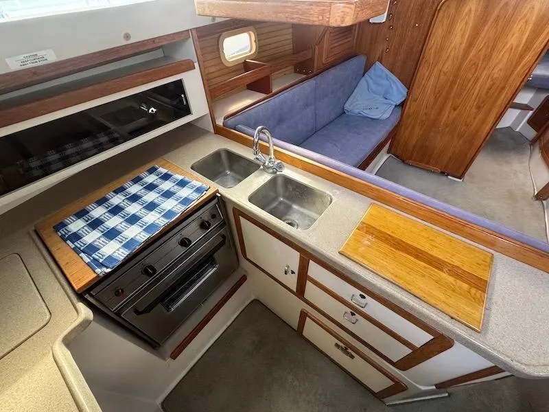 Slide: The Image of Interior of a 1995 Catalina 30 yacht with kitchen and seating area. - 34
